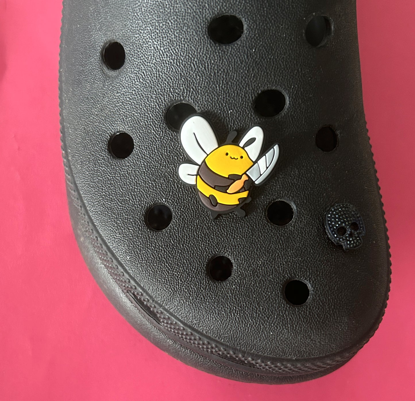 Fat bee holding a knife shoe charm.