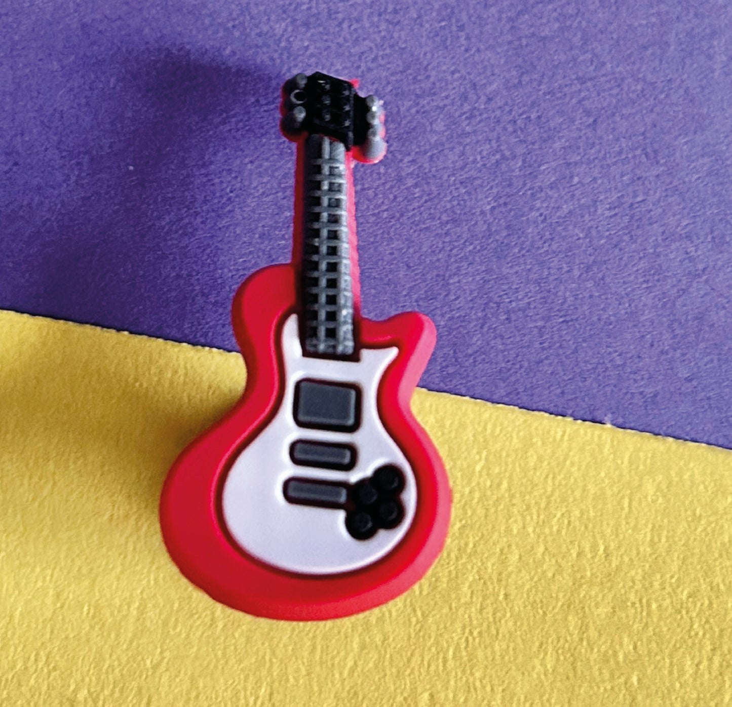 Red electric guitar croc like shoe charm.