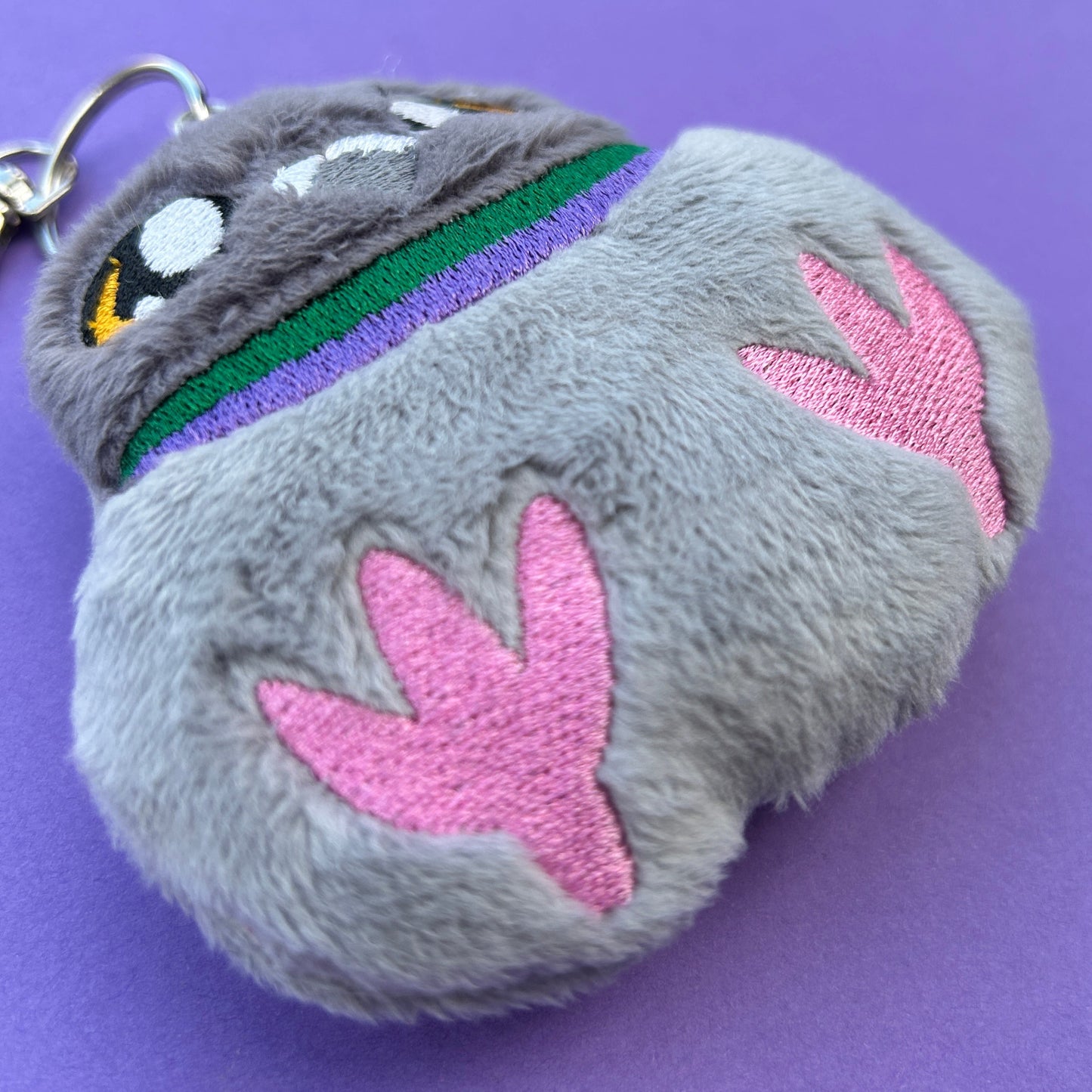 Cute chubby pigeon bag charm handmade embroidery design. Closeup.