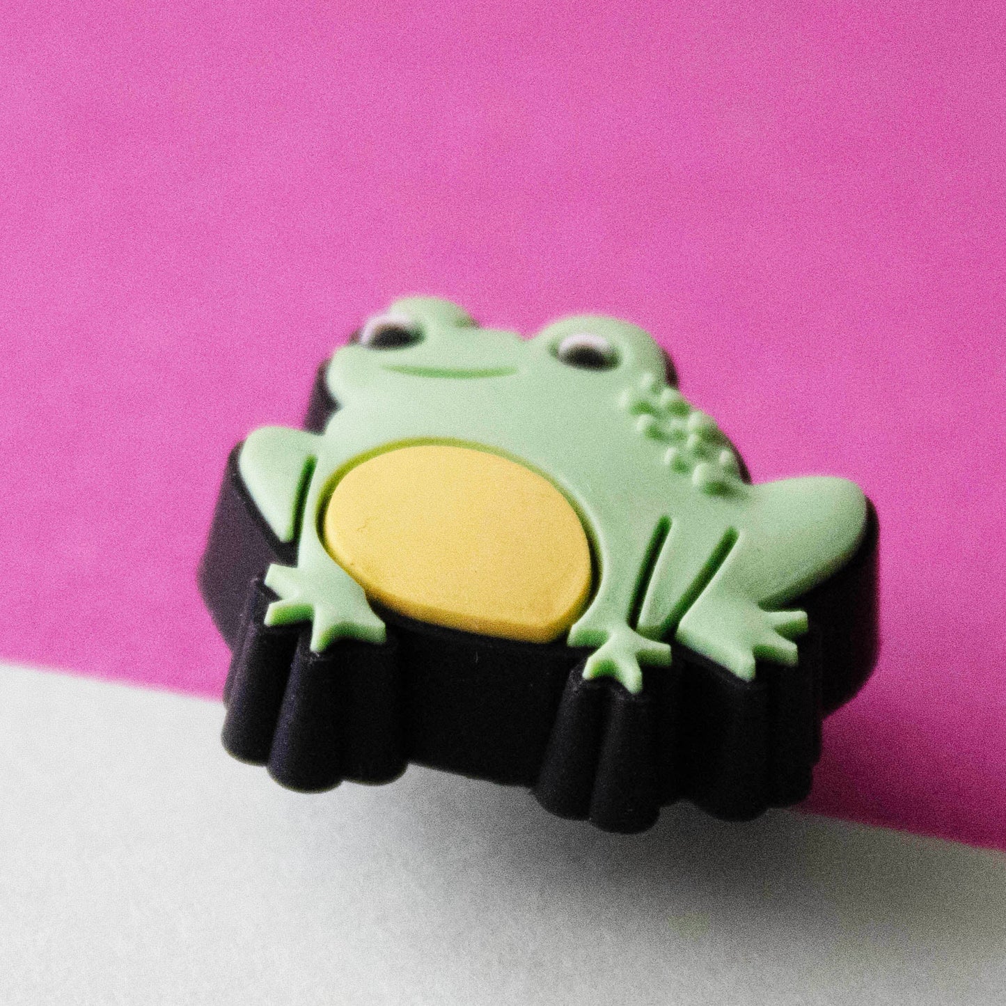 Green small frog croc like shoe charm. Close up image.