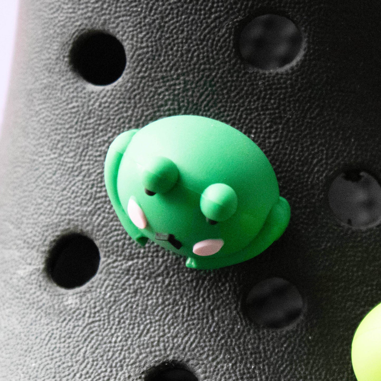 Green 3D Frog croc like shoe charm. Modelled on a black croc shoe. Top down view.
