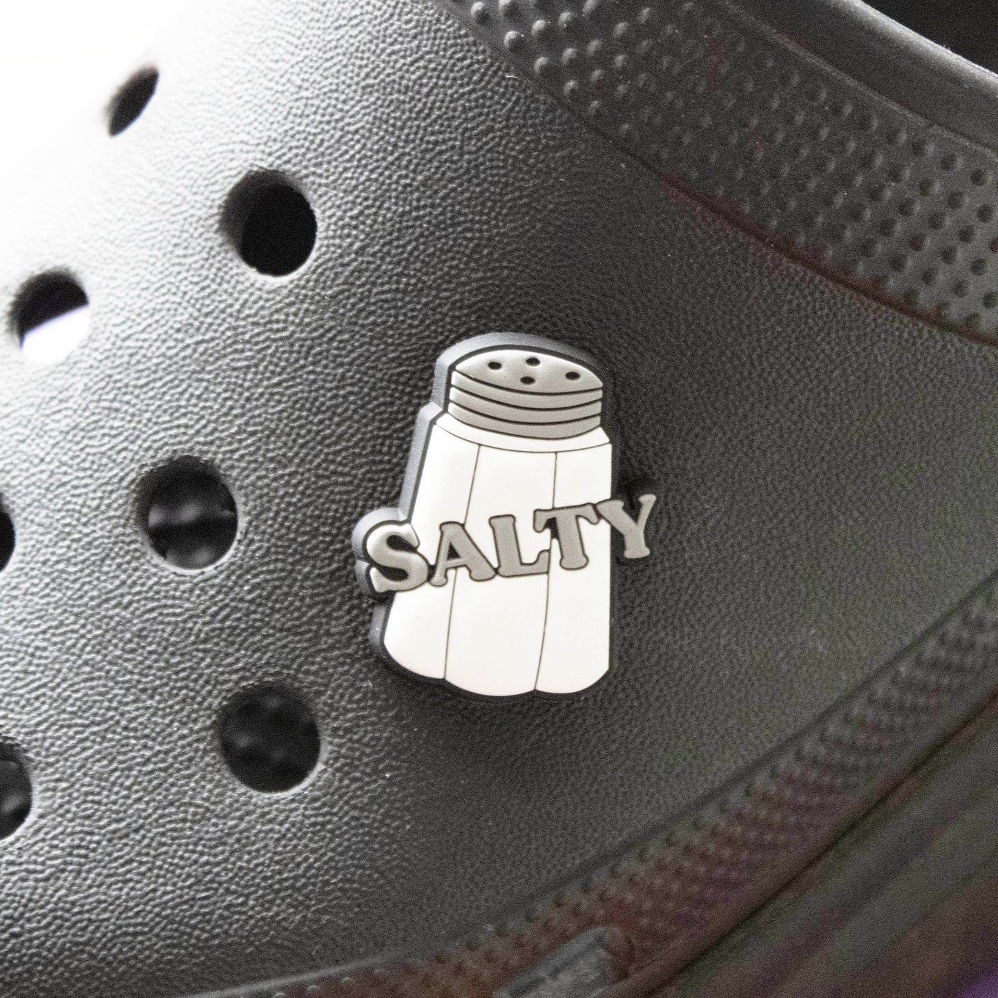 Salty Slogan croc like shoe charm. Barcoded. Shown on a black croc shoe.