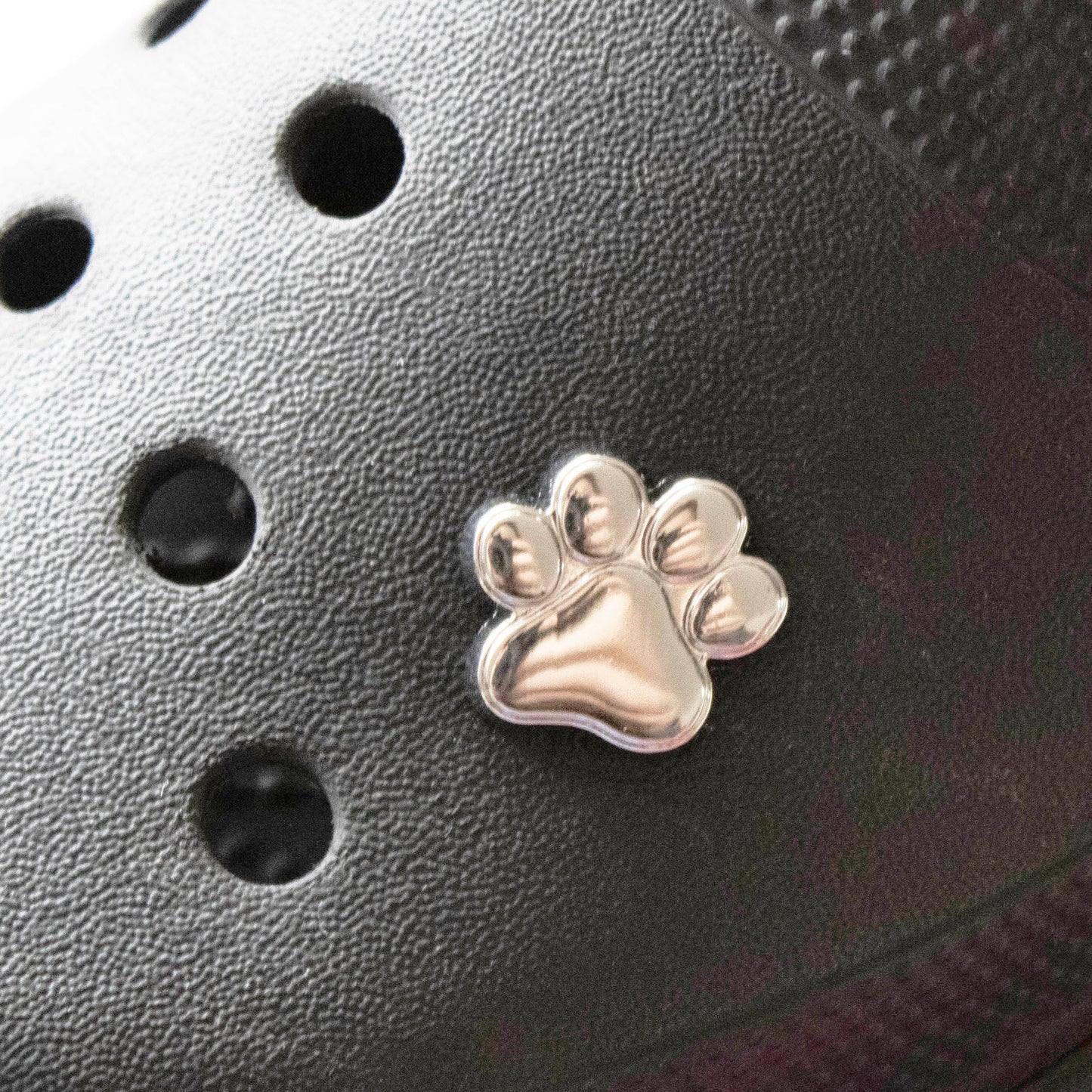 Solid Silver Metal dog paw. Premium croc charm. Shown on a black croc shoe.