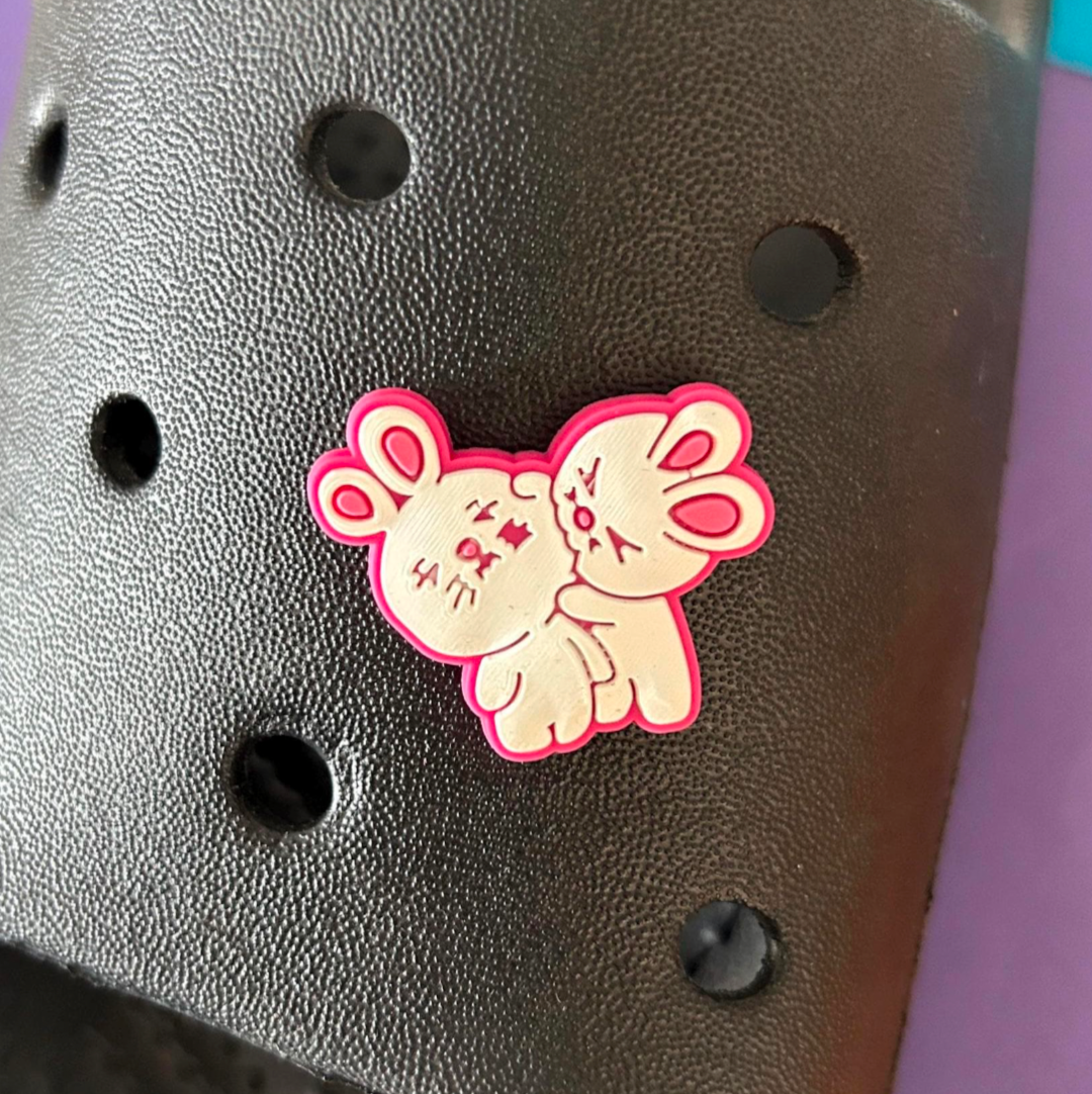 Biting Love Rabbits croc like shoe charm. Shown on a black croc shoe.