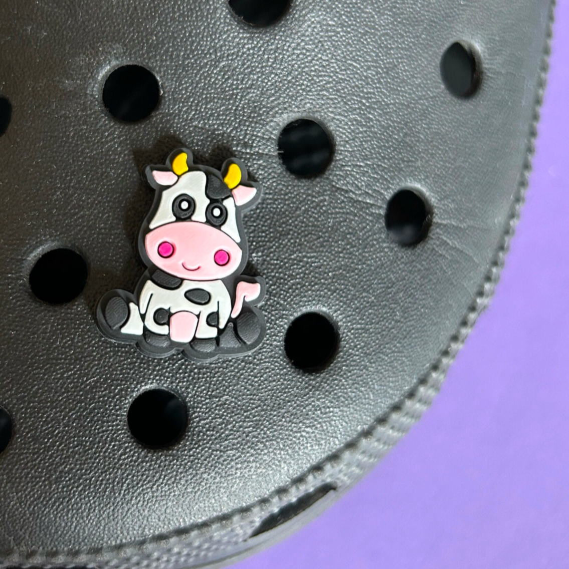Cute Cow croc like shoe charm. Shown on a black croc shoe.