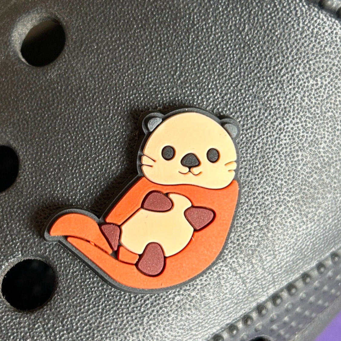 Cute Otter croc like shoe charm. Shown on a black croc shoe.