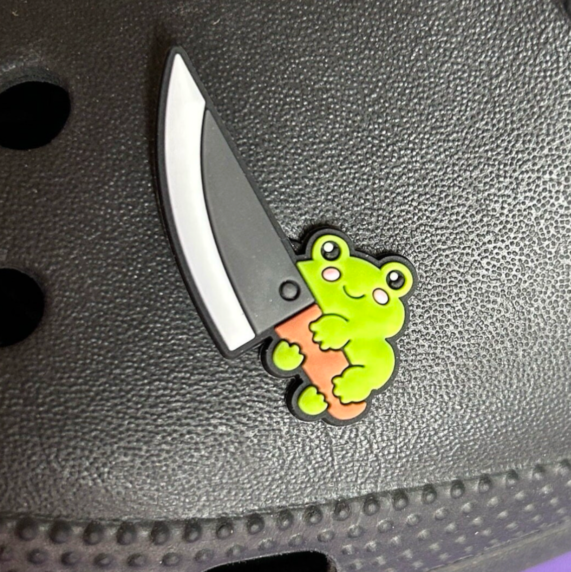 Frog with a big knife croc like shoe charm. Shown on a black croc shoe.