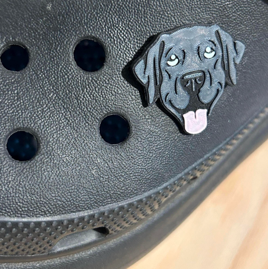 Handmade 3D Printed Black Labrador Dog, croc like shoe charm. Shown on a black croc shoe. Side view.
