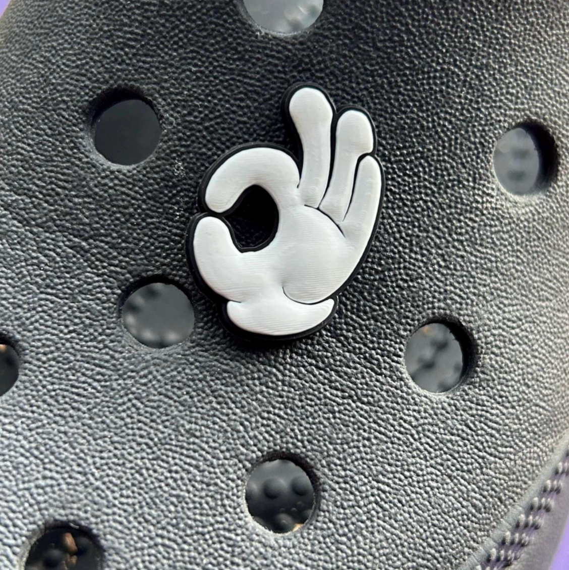 OK White Glove croc like shoe charm. Shown on a black croc.