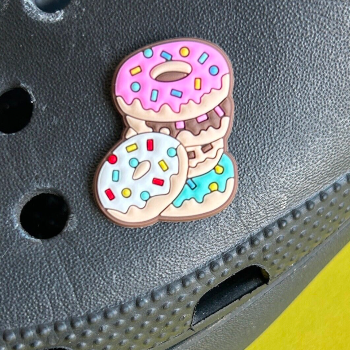 Pile of Doughnuts croc like shoe charm. Shown on a black croc shoe.