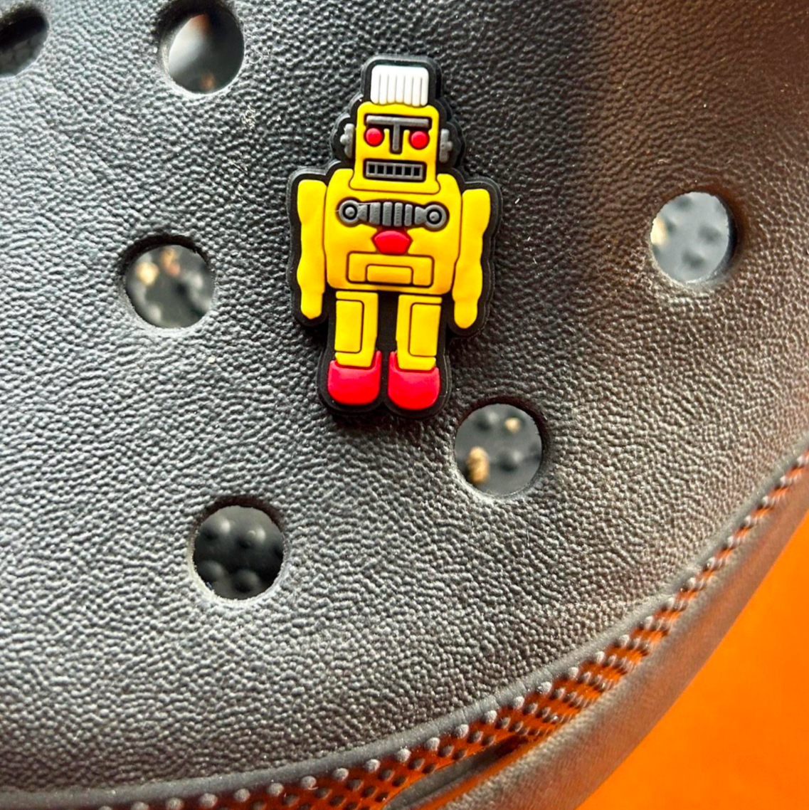 Yellow Robot croc like shoe charm. Shown on a black croc shoe.