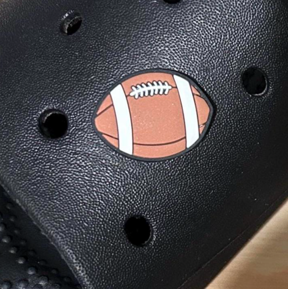 Rugby Ball sport croc like shoe charm. Shown on a black croc shoe.
