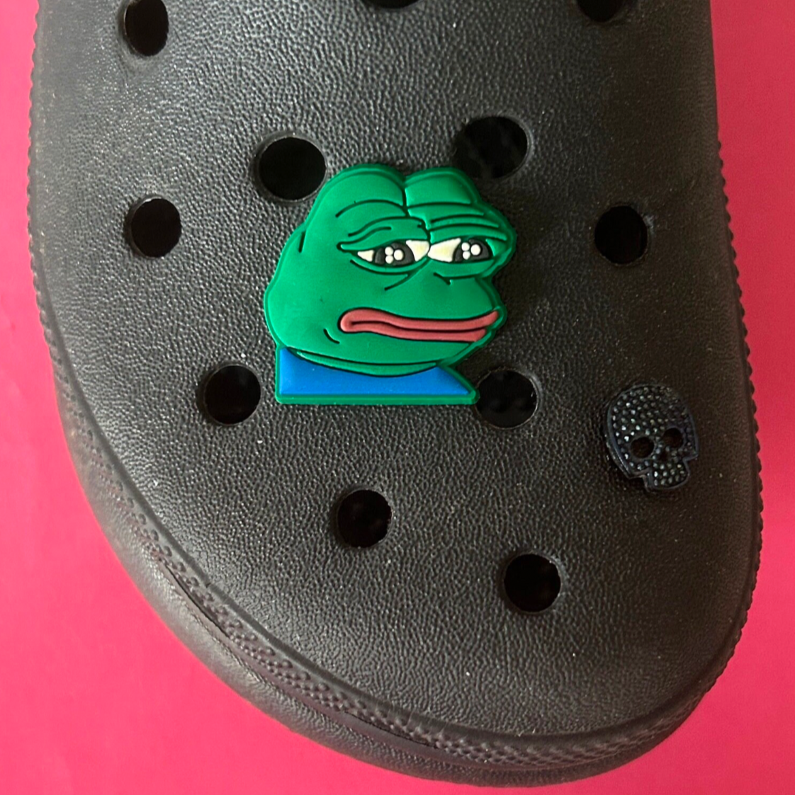 Sad Frog Meme croc like shoe charm. Shown on a black croc shoe.