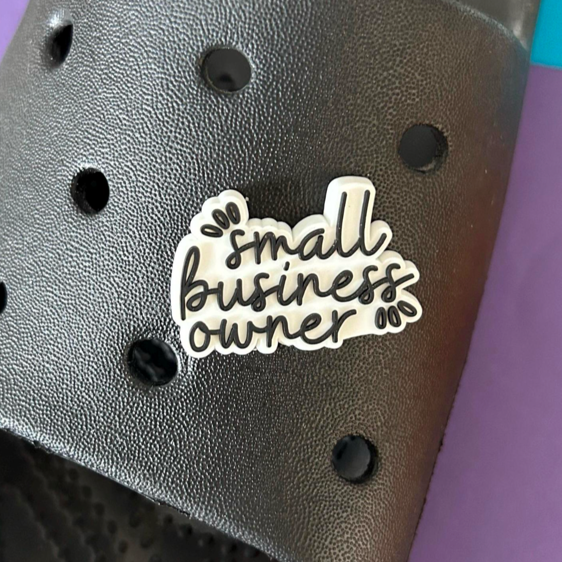 Small business owner slogan croc like shoe charm. Shown on a black croc shoe.
