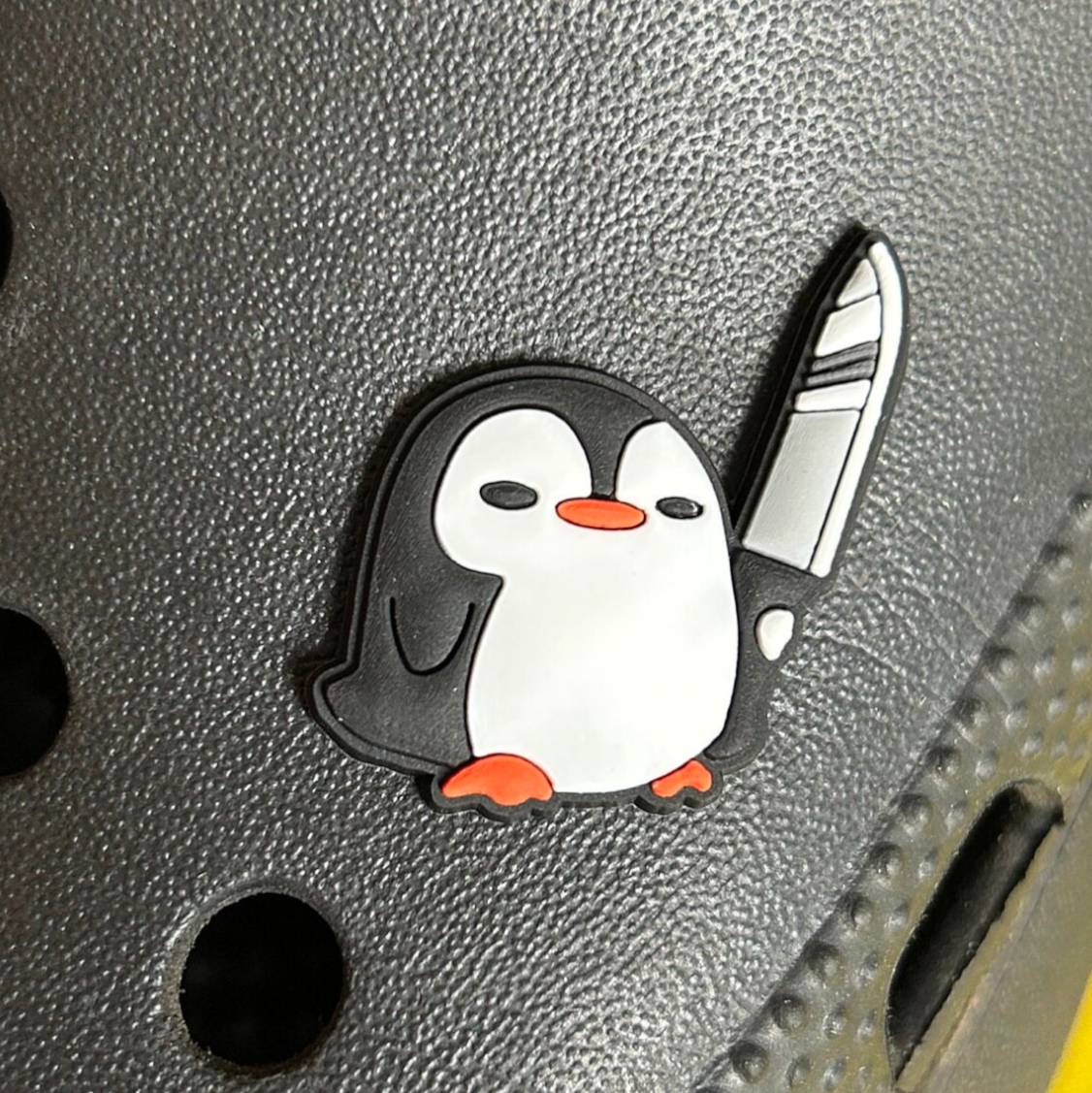 Stabby Penguin croc like shoe charm. Shown on a black croc shoe.