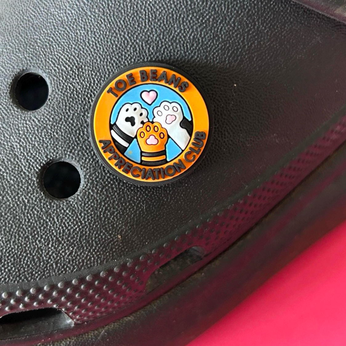 Toe bean appreciation club croc like shoe charm. Shown on a black croc shoe.
