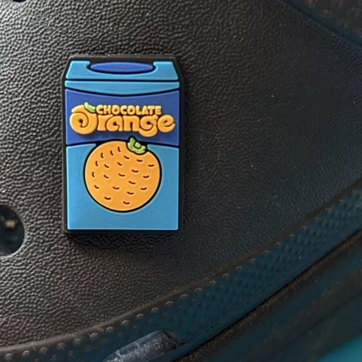 Chocolate Orange croc like shoe charm. Shown on a black croc shoe.