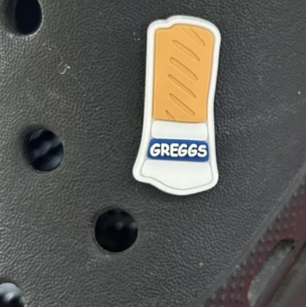 Sausage Roll croc like shoe charm. Shown on a black croc shoe.