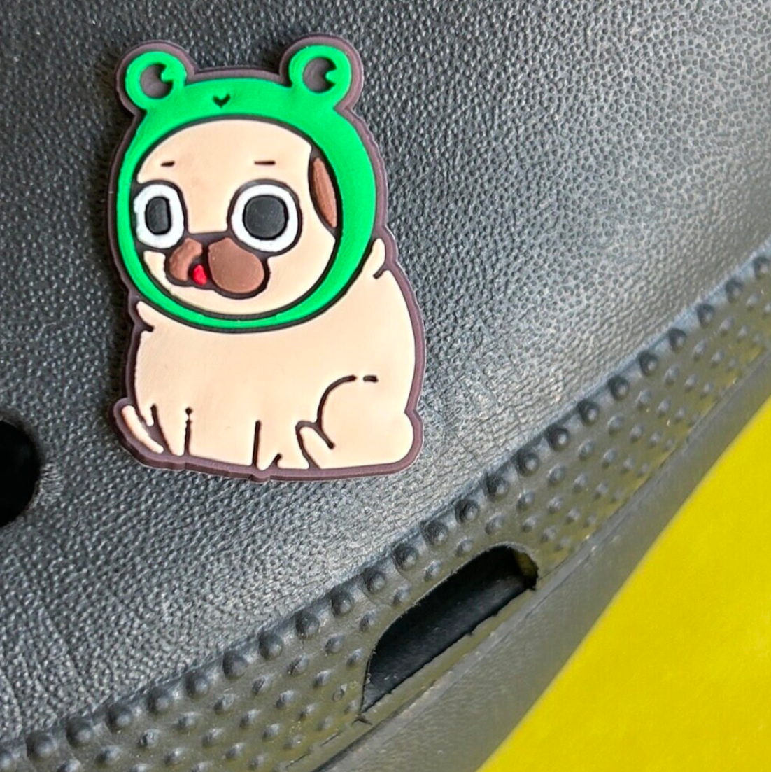 Pug Dog wearing a Frog Hat croc like shoe charm. Shown on a black croc shoe.