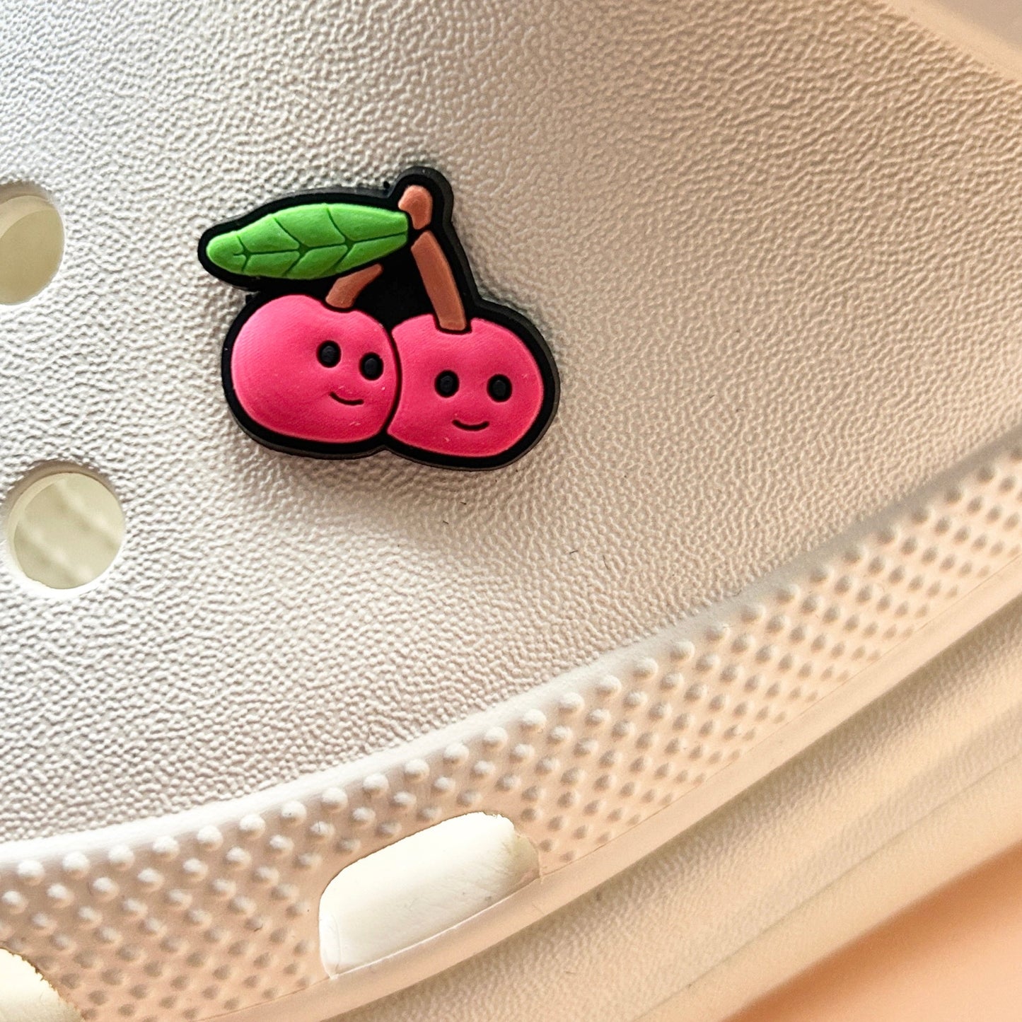 Smiley Cherries croc like shoe charm. Shown on a cream croc shoe.
