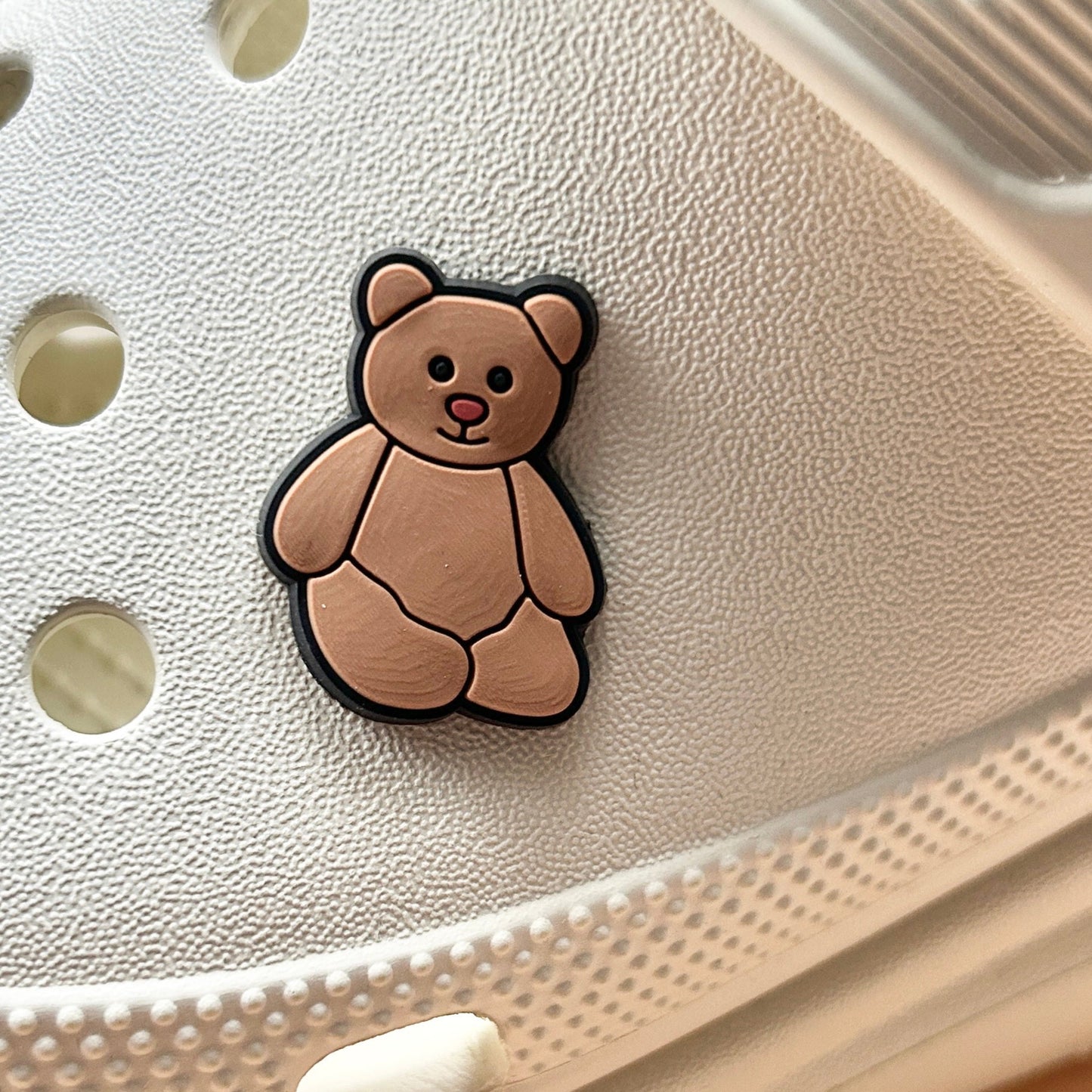 Brown Teddy Bear croc like shoe charm. Shown on a cream croc shoe.