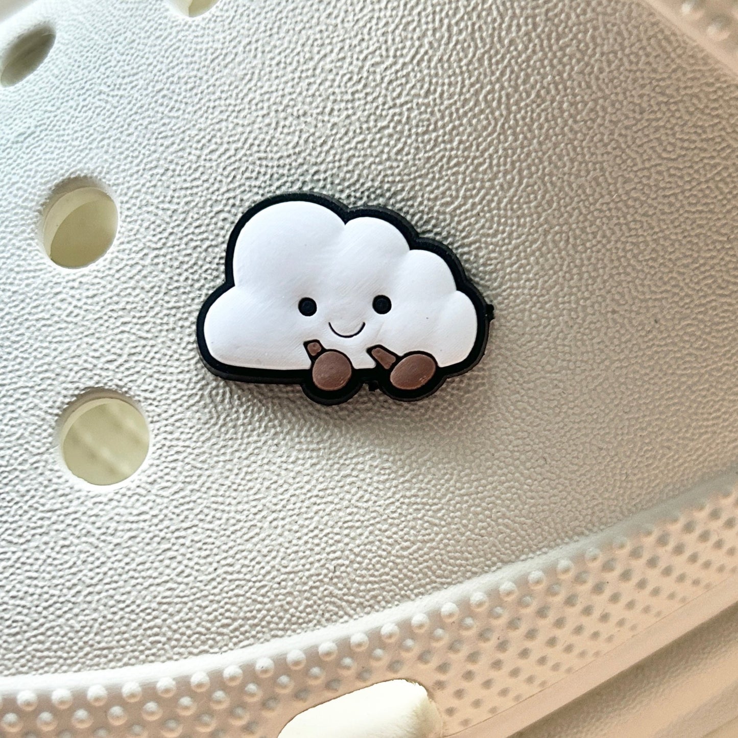 Cloud croc like shoe charm. Shown on a cream croc shoe.