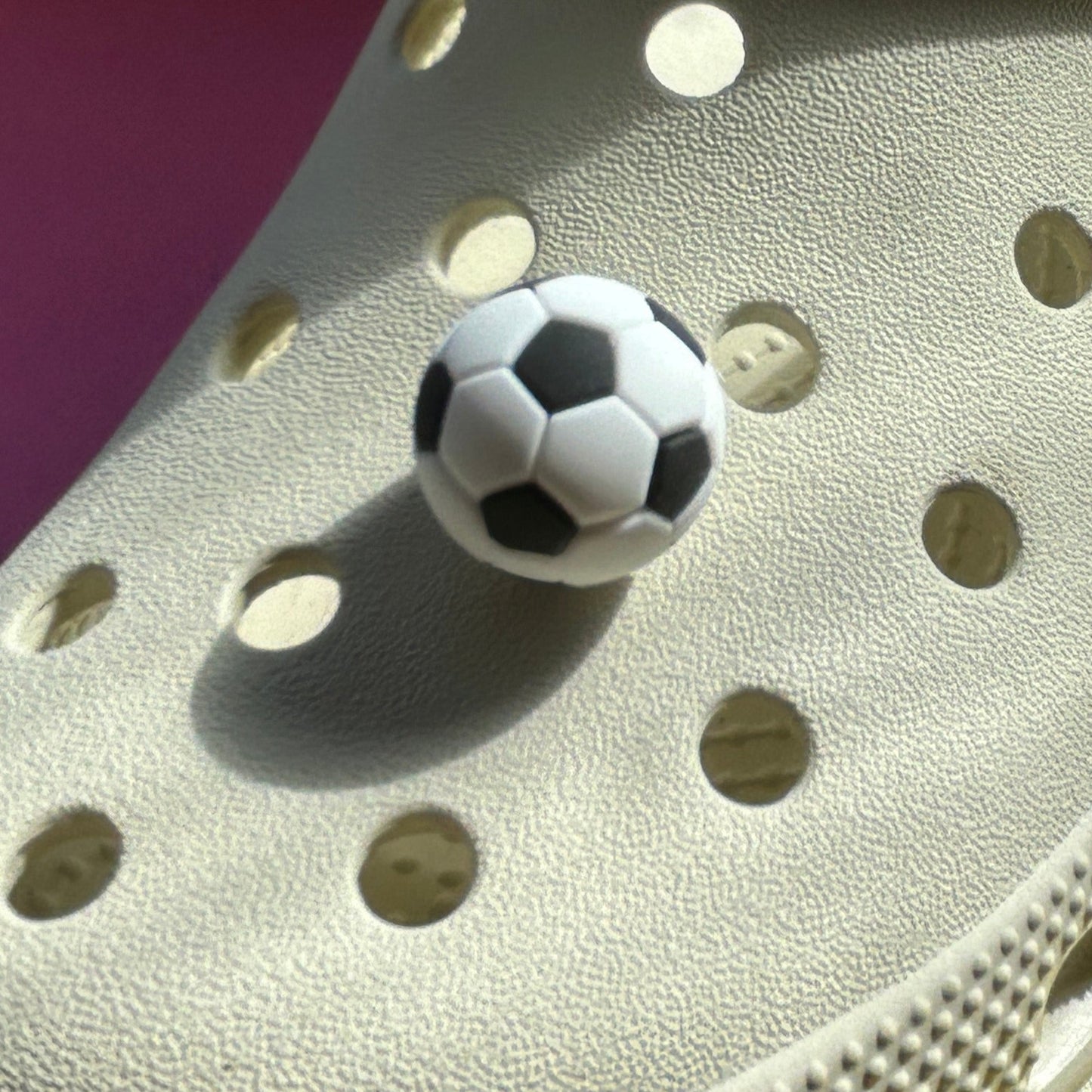 3D White and Black football croc shoe charm. Sport. Modelled on a cream croc shoe. Shown on the front.