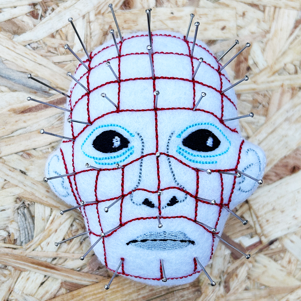 Pinhead from hellraiser pin cushion photographed on a wooden background