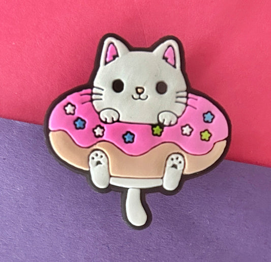 Cat sitting in a donut croc charm. 