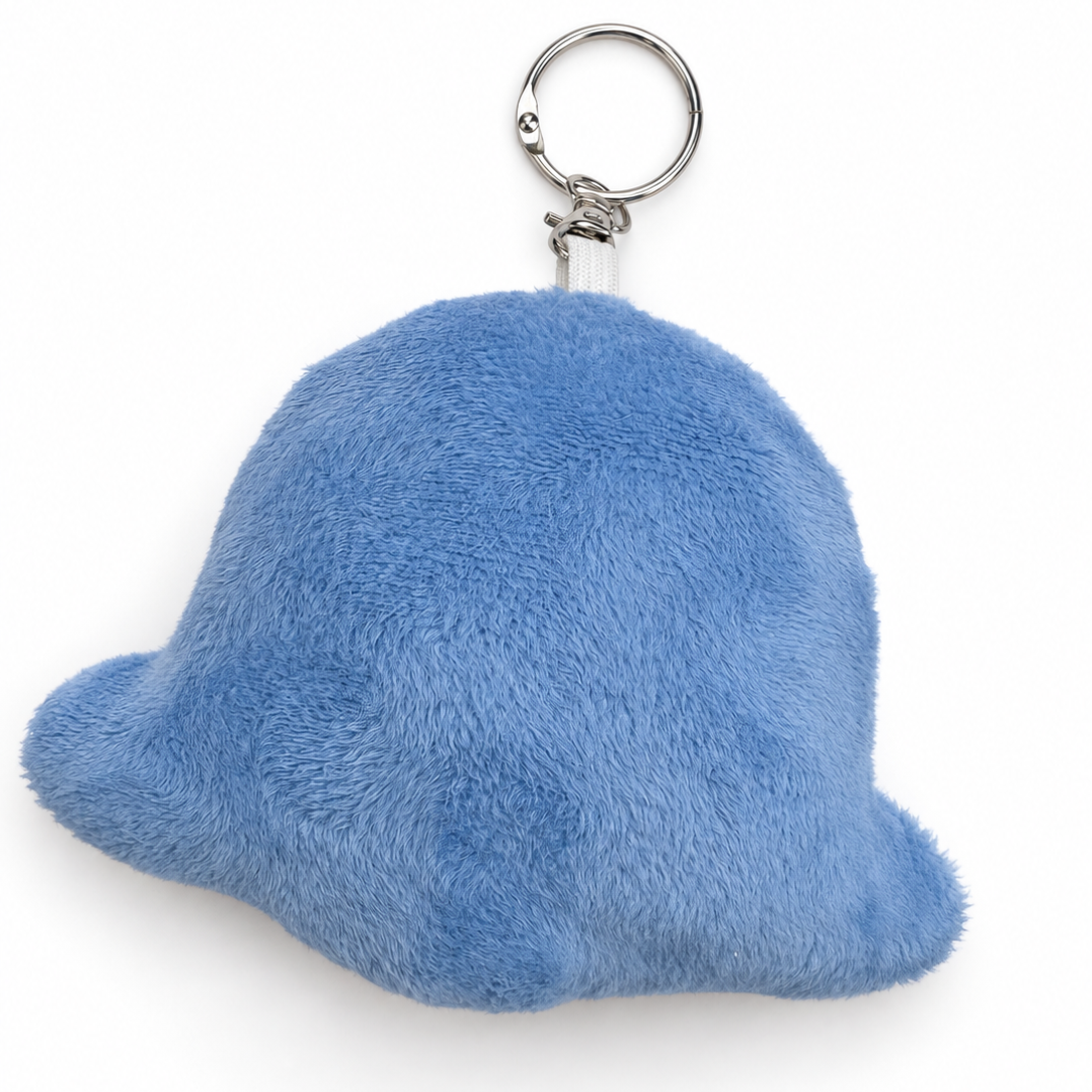 A light blue fuzzy plush keychain shaped like a small rounded character or blob, attached to a silver metal split ring, shown on a plain white background.