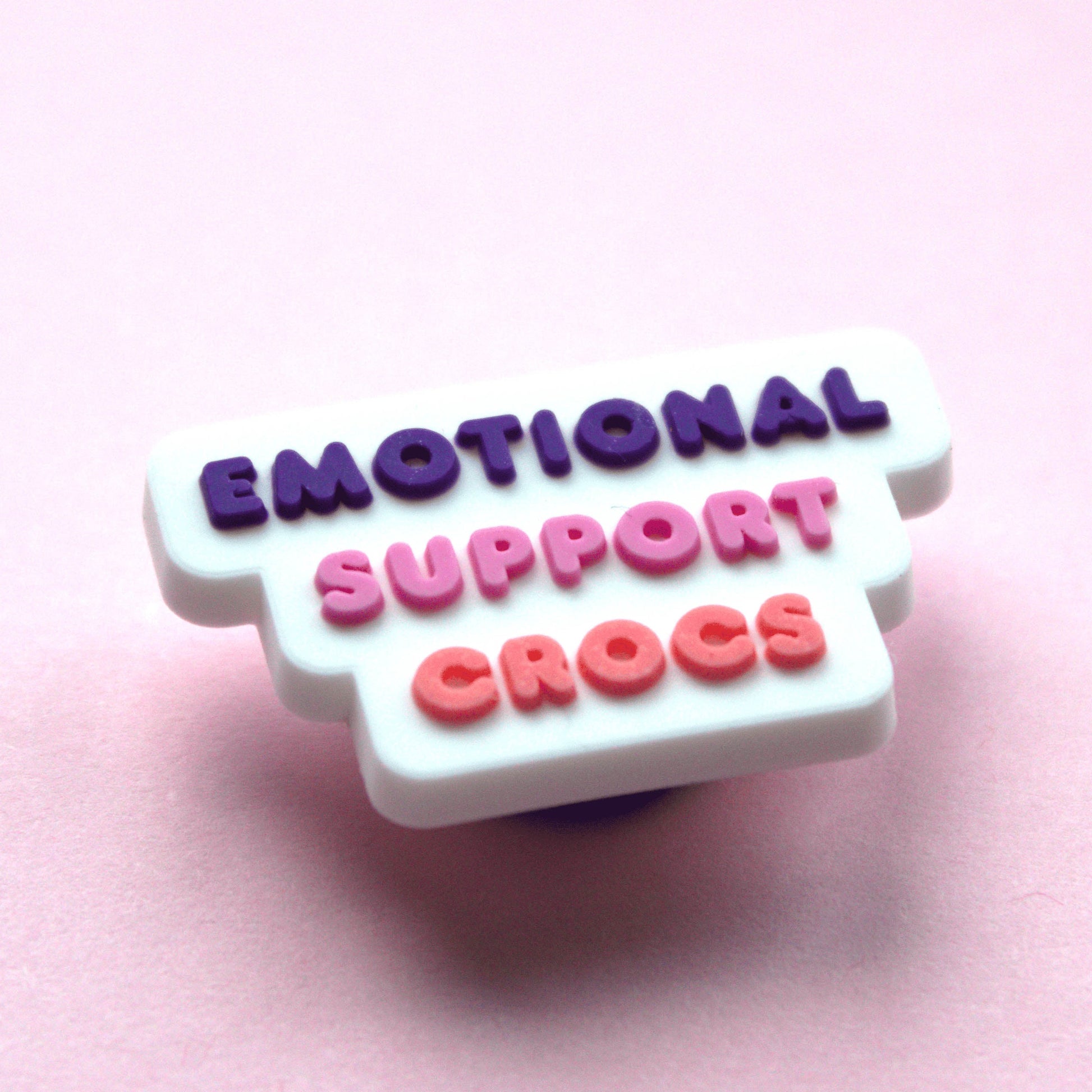 Emotional Support Crocs Slogan croc like shoe charm. White, pink and purple. Close up image. 