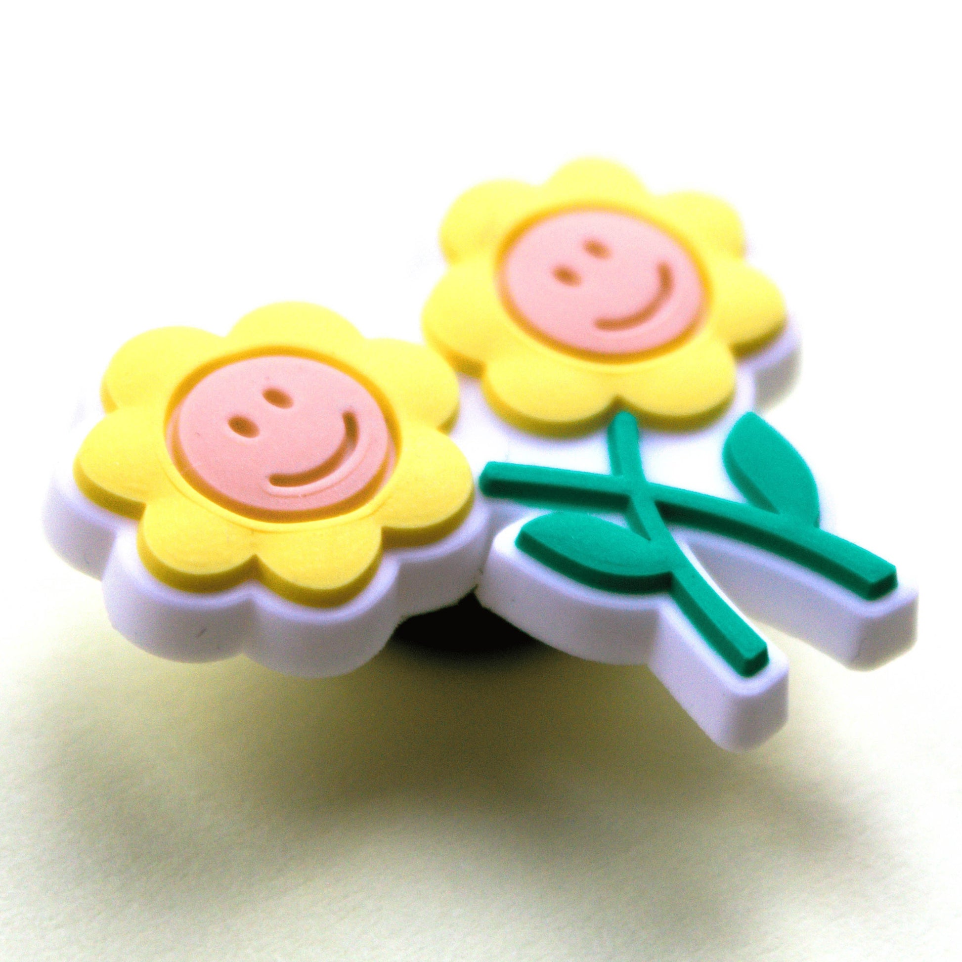 Two smiley Flowers croc like shoe charm. Close up image.