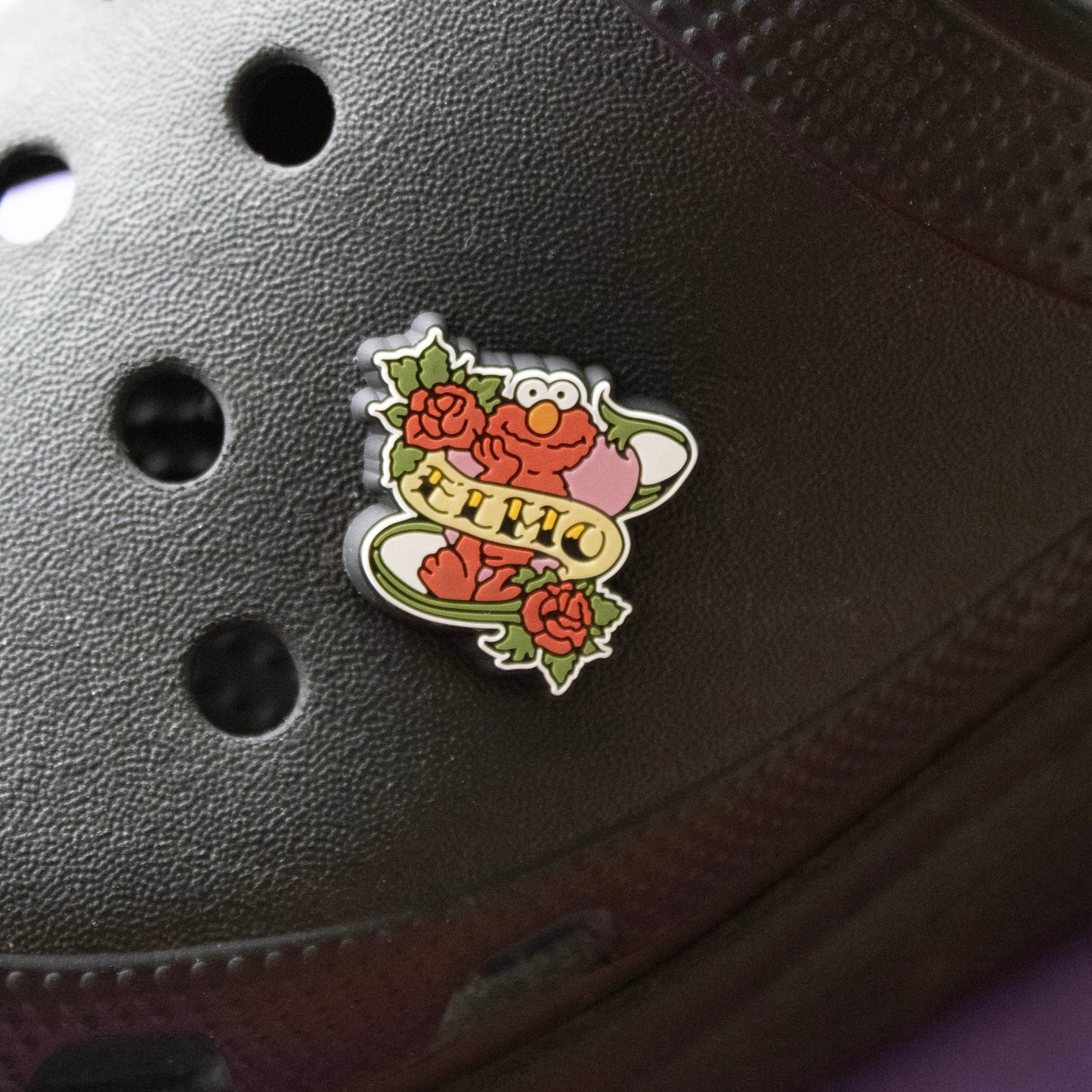 Polite Red Monster Tattoo look croc like shoe charm. Shown on a black croc shoe. 