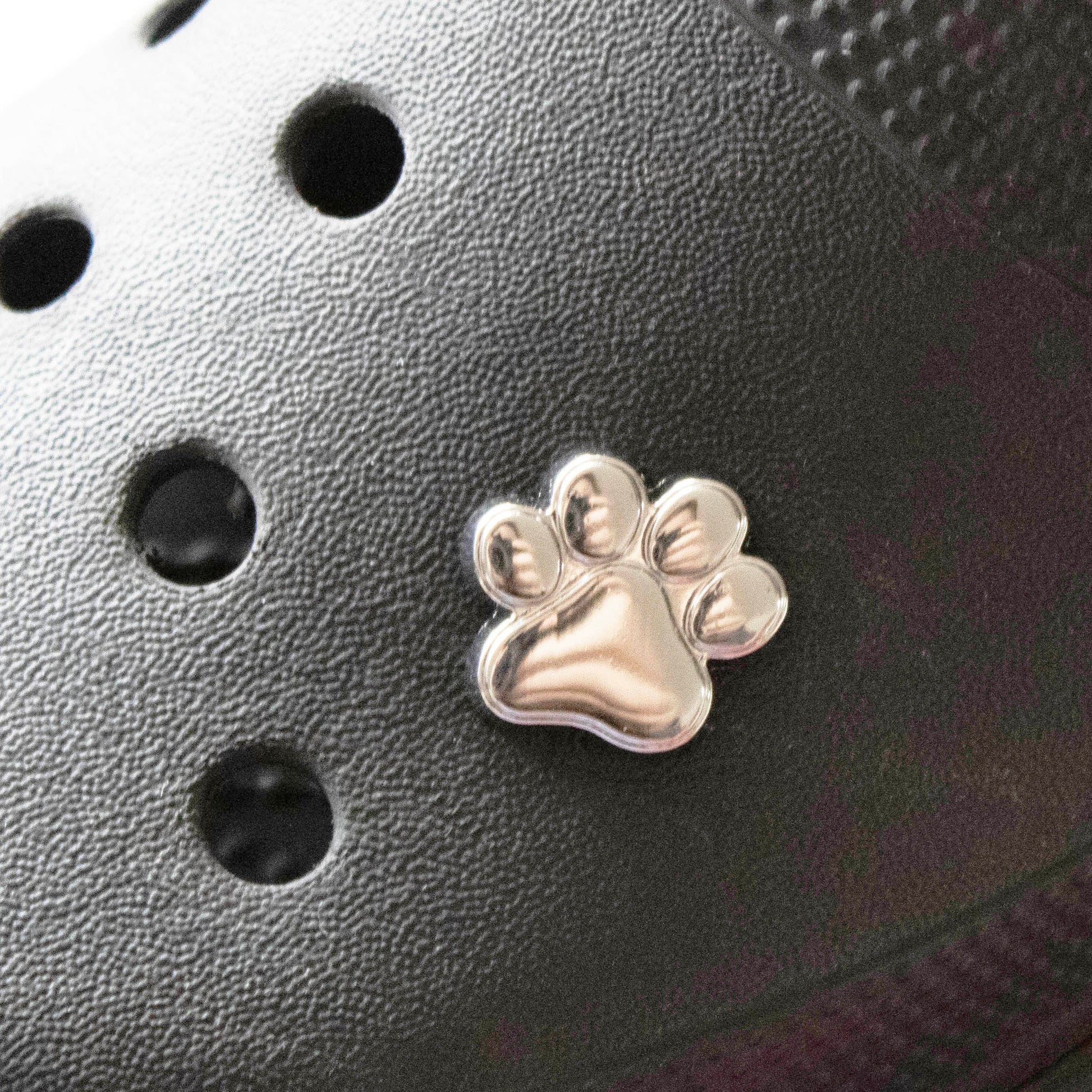 Solid Silver Metal dog paw. Premium croc charm. Shown on a black croc shoe. 