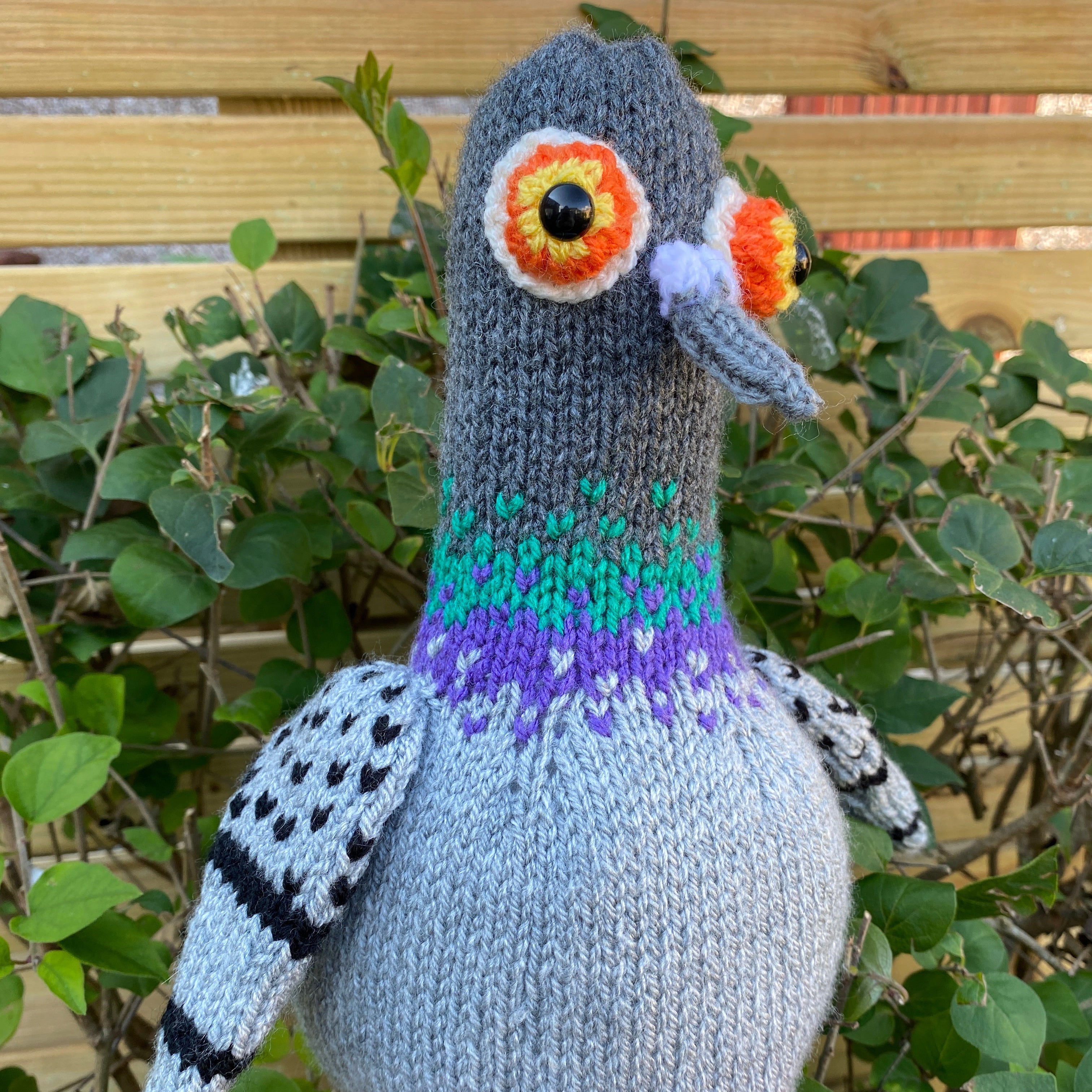 Knitted pigeon toy with oversized eyes and wings