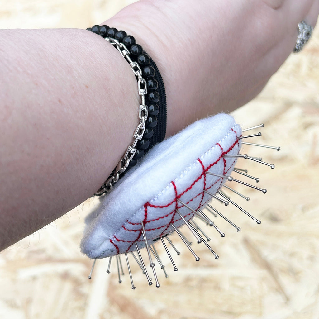 Wrist showing side profile of a pinhead pincushion. Handmade. 