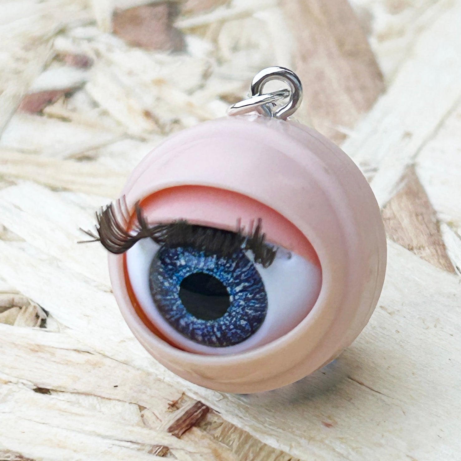 Doll eye stitch marker  on a wooden surface