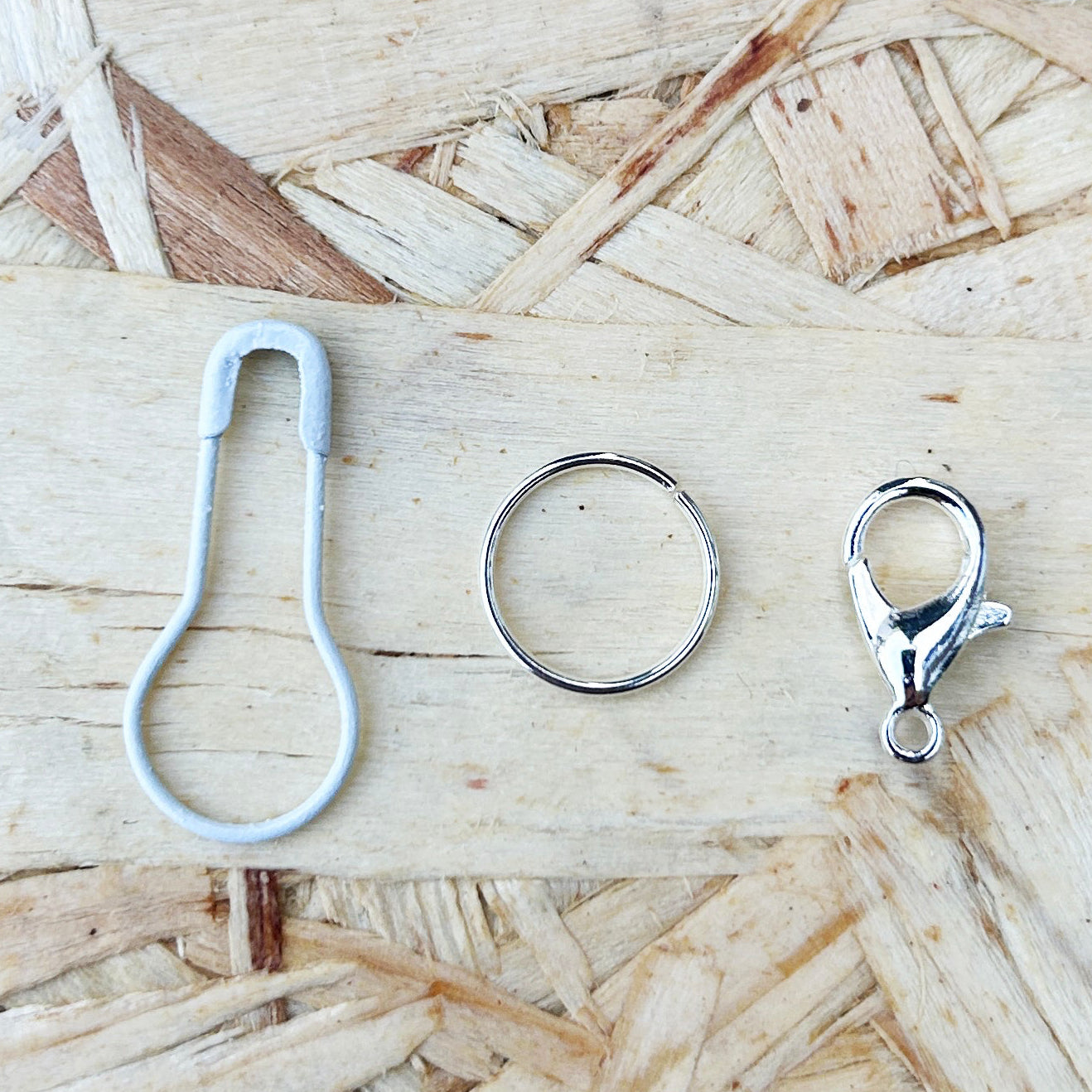 Three metal charms on a bed of wood