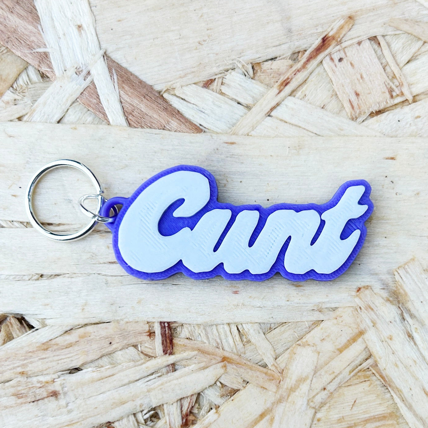 Offensive word cunt stitch marker on a wooden background