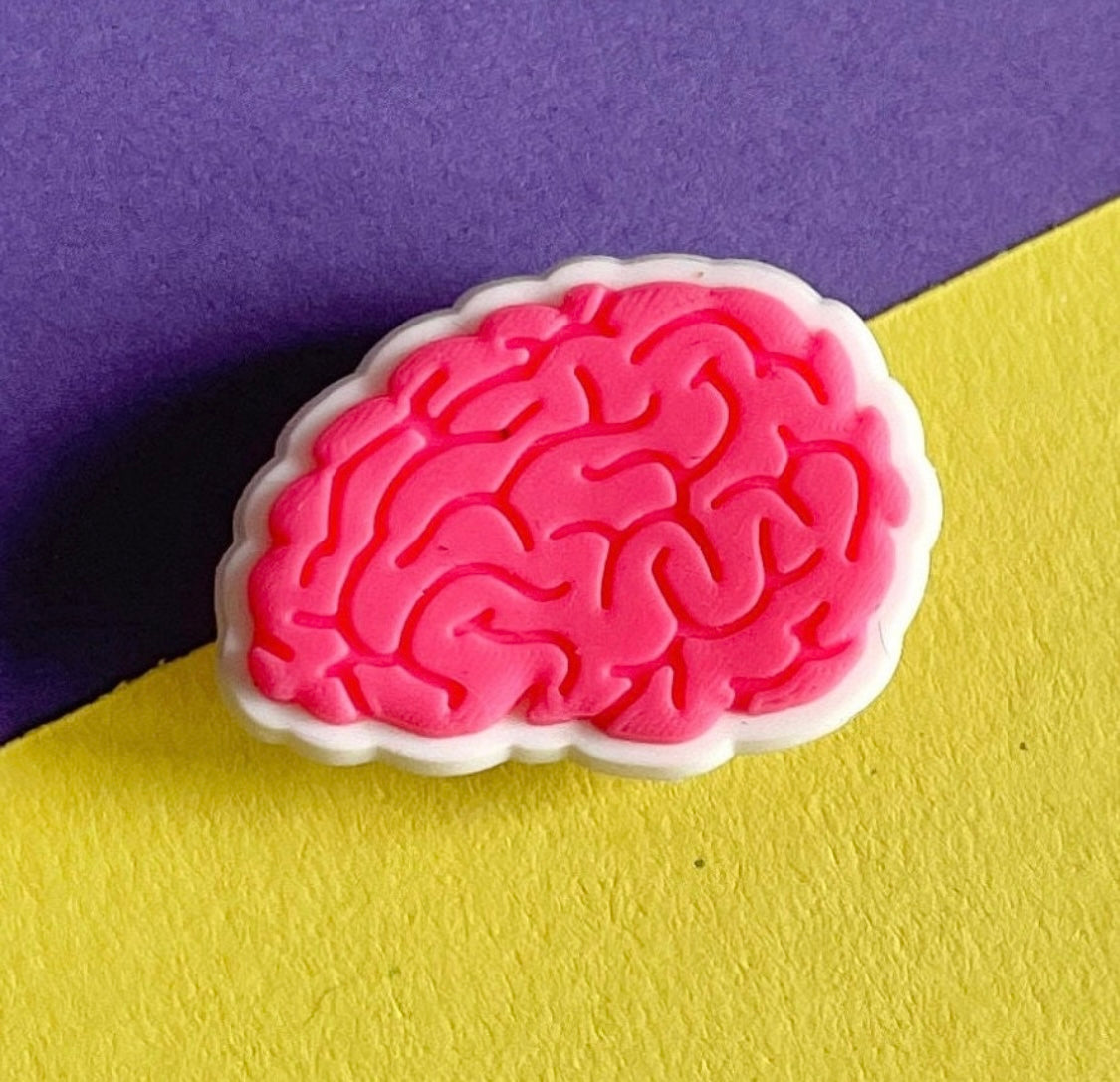 Pink shoe charm in the style of a human brain. 