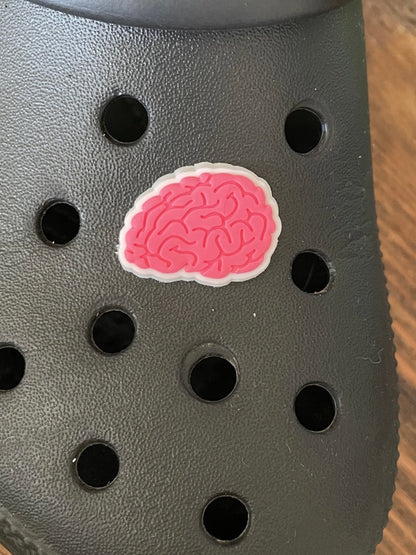 Pink brain shoe charm on a croc shoe.