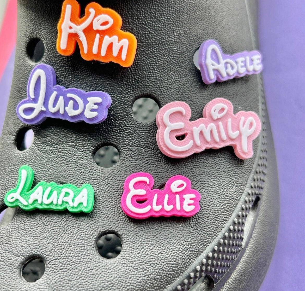 3D Printed personalised croc Name charms. Examples shown on a black croc shoe. 