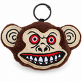 A plush monkey head keychain or bag charm with a black metal key ring. The design features brown fuzzy fur, beige embroidered skin, red and black embroidered eyes, and a wide grin showing white and black teeth.