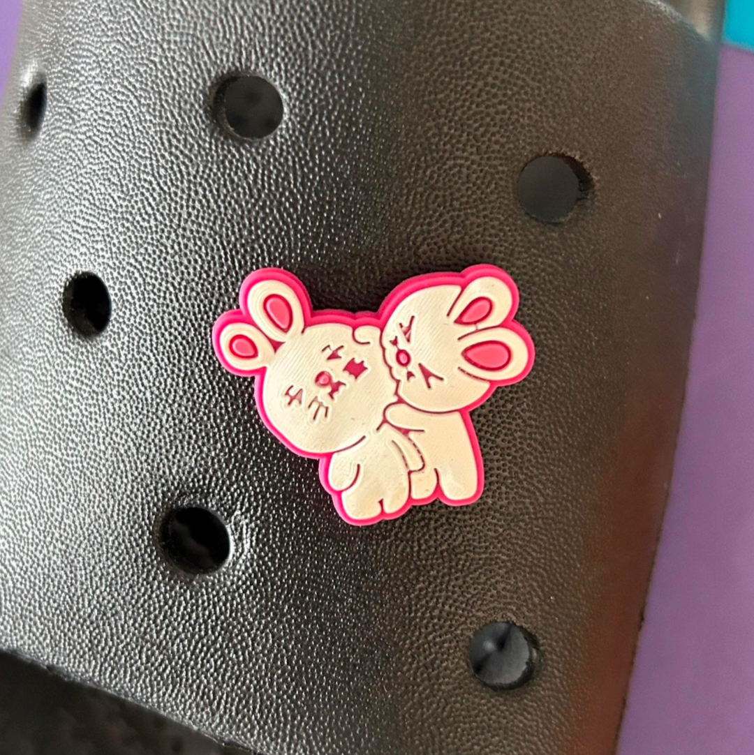 Biting Love Rabbits croc like shoe charm. Shown on a black croc shoe. 