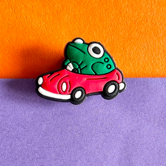 Frog driving a red car croc like shoe charm.