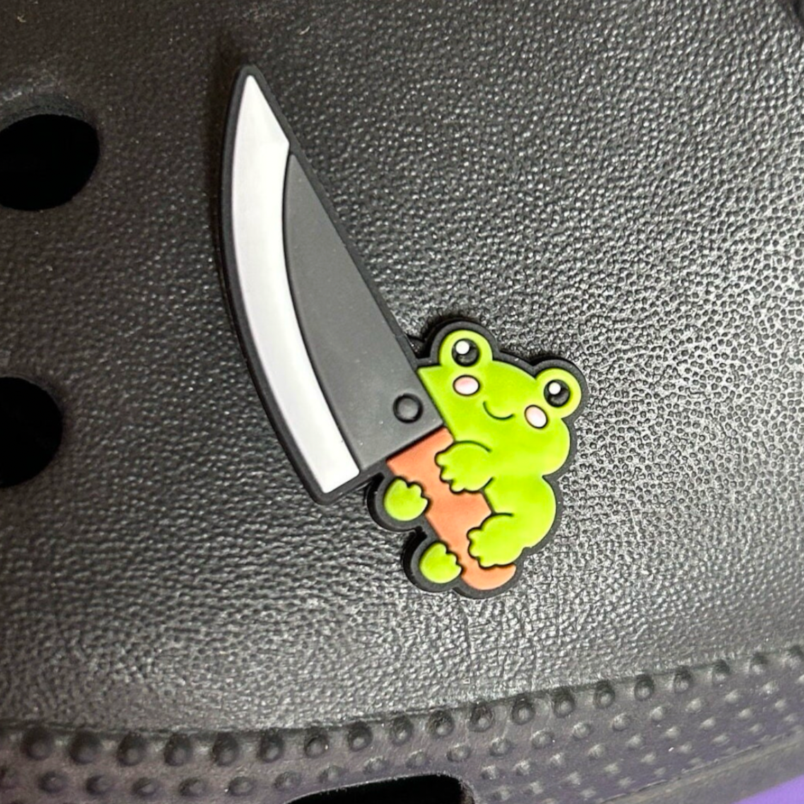 Frog with a big knife croc like shoe charm. Shown on a black croc shoe. 