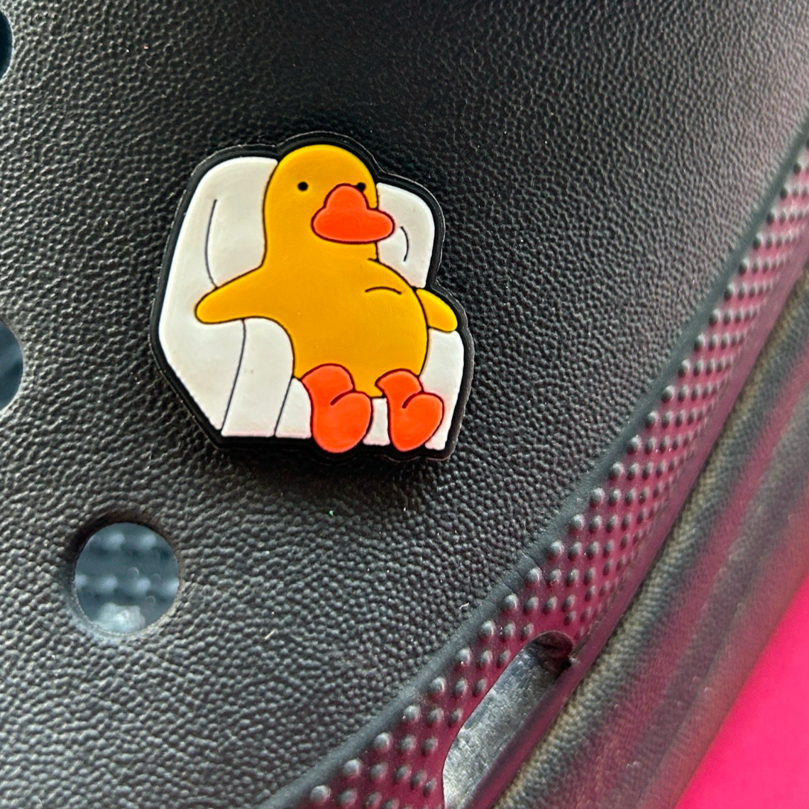 Lazy Chick in a Chair croc like shoe charm. Shown on a black croc shoe. 