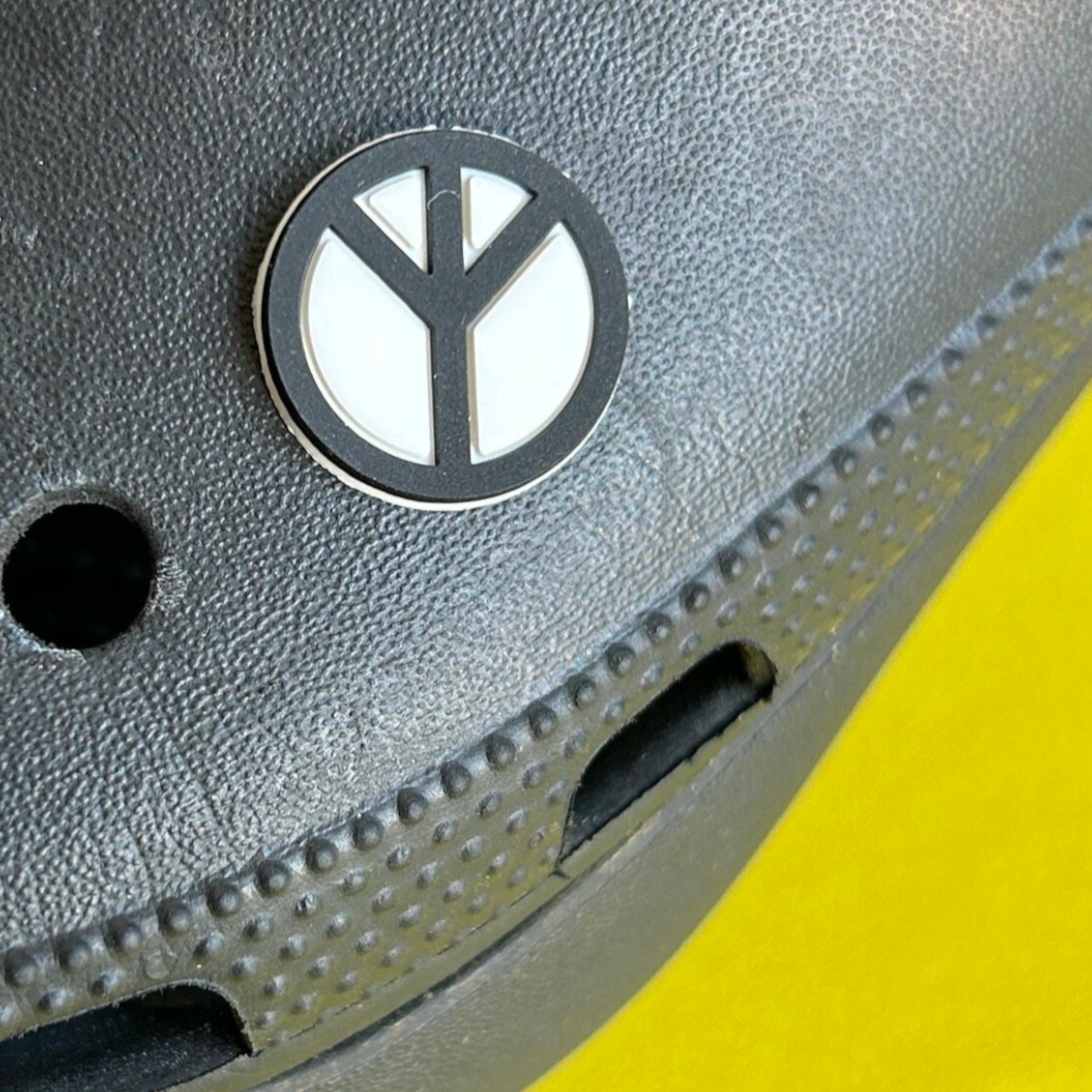 Black and White peace Symbol croc like shoe charm. Shown on a black croc shoe.