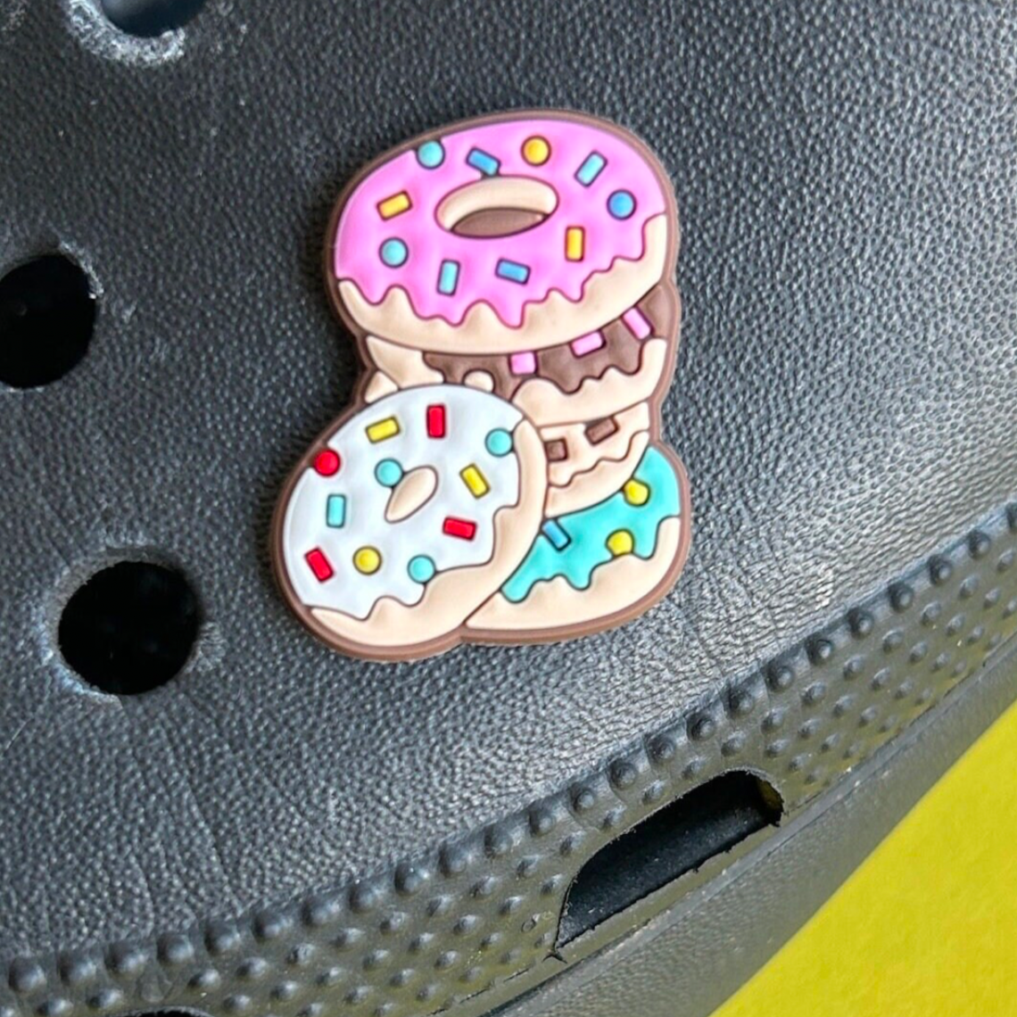 Pile of Doughnuts croc like shoe charm. Shown on a black croc shoe. 