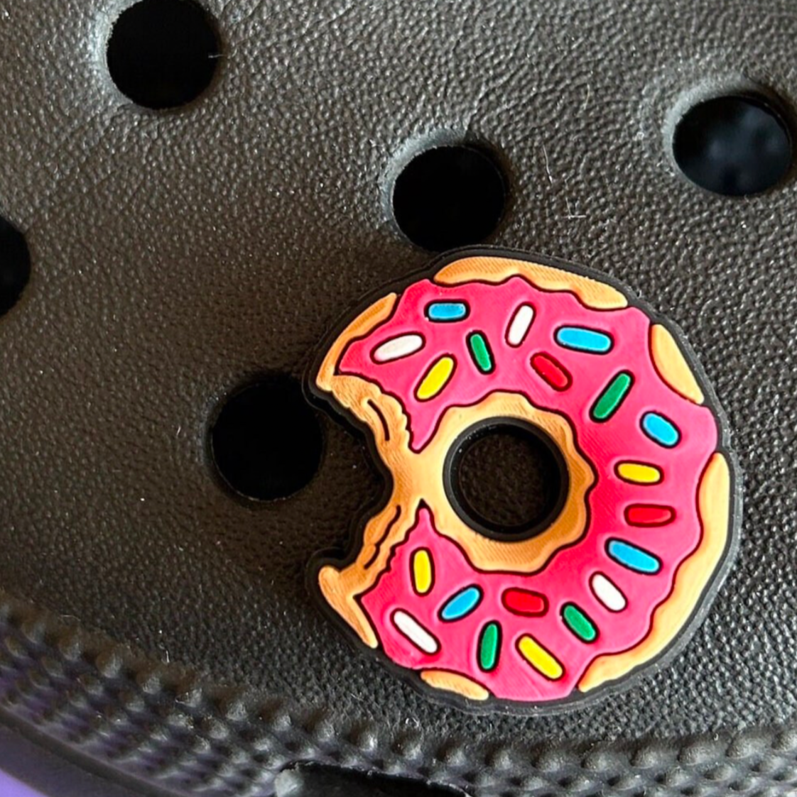 Pink Iced Doughnut croc like shoe charm. Shown on a black croc shoe. 